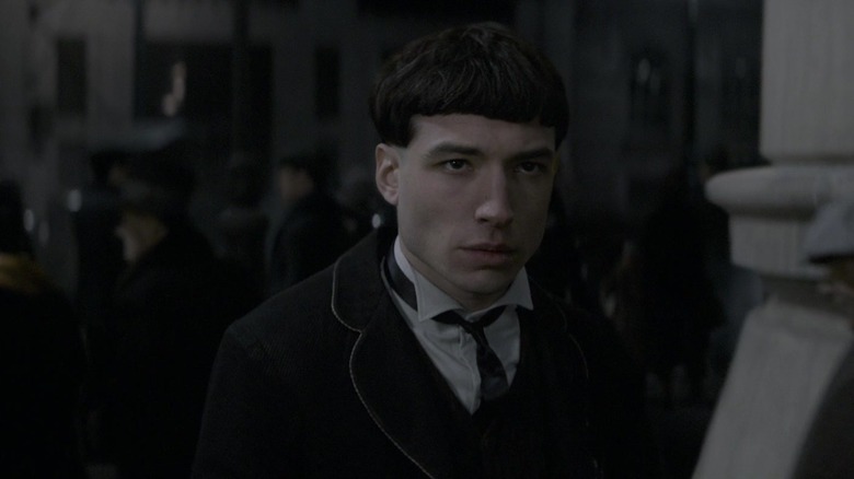 Ezra Miller as Credence in suit and bowl haircut