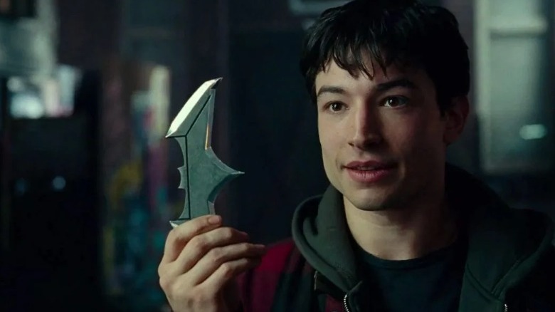 Ezra Miller holding a batarang