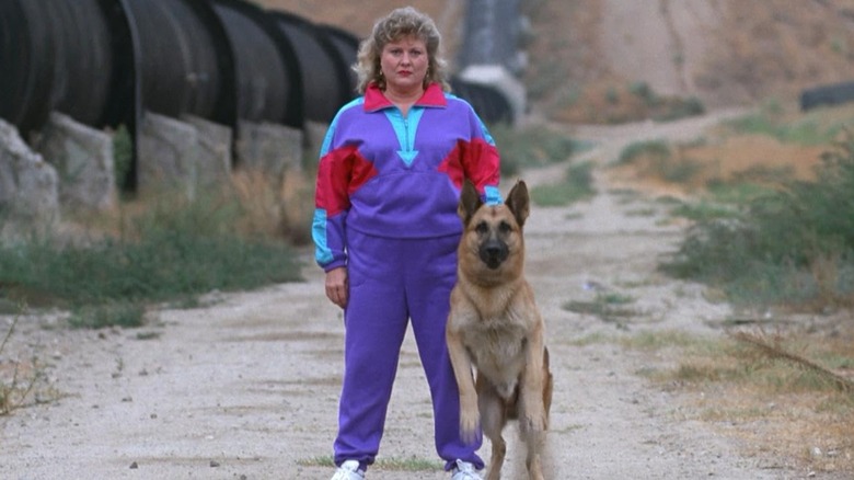 A dog walker in a '90s tracksuit with her dog in Amityville: It's About Time
