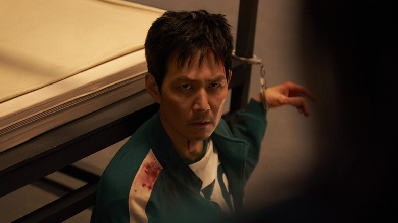 Gi-hun is handcuffed to a bed in "Squid Game" (2021-2025)