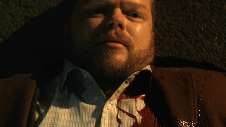 Foggy lying on the ground with blood on his jacket