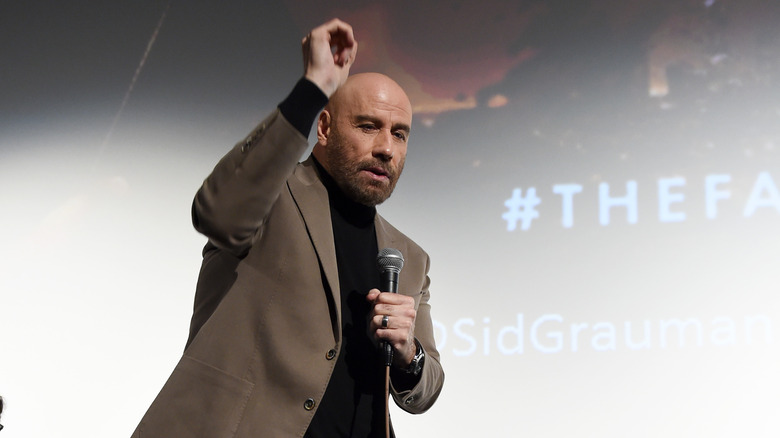 a bald John Travolta dancing
