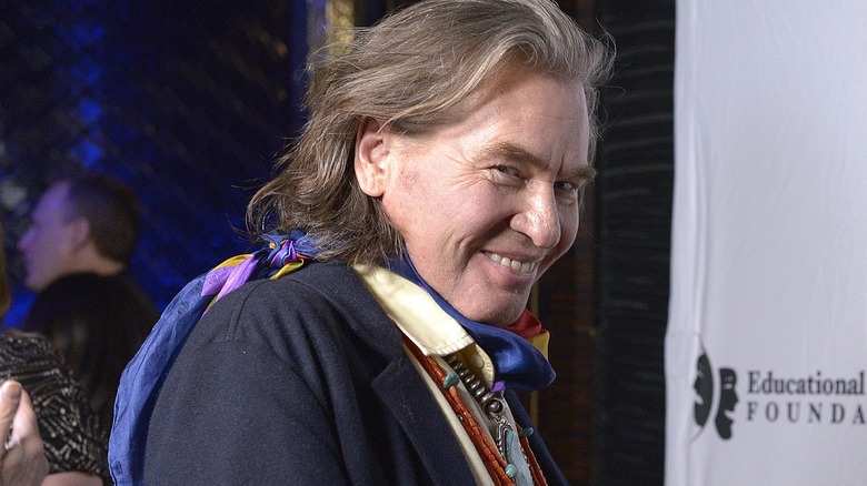 Val Kilmer smiling over shoulder at event (2019)