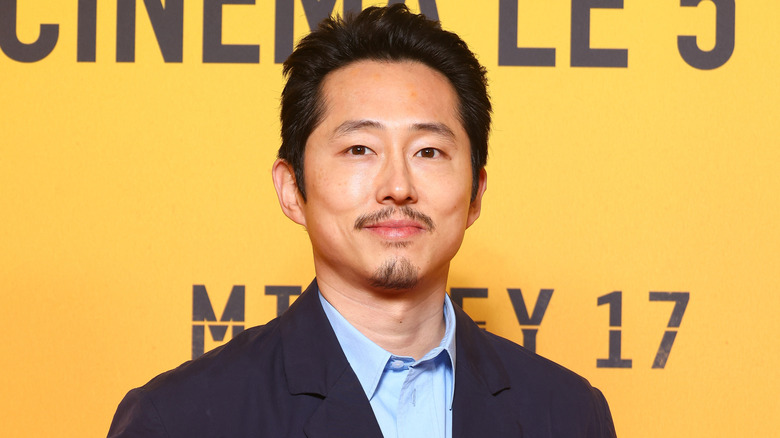 Steven Yeun smiling at the French premiere of 