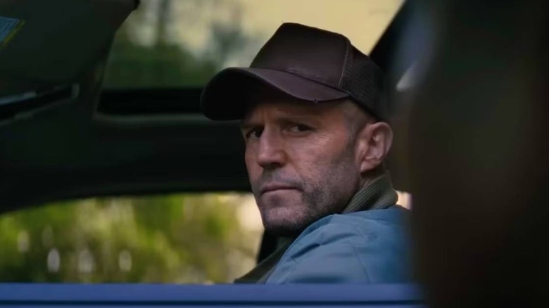 Levon Cade driving a car in A Working Man